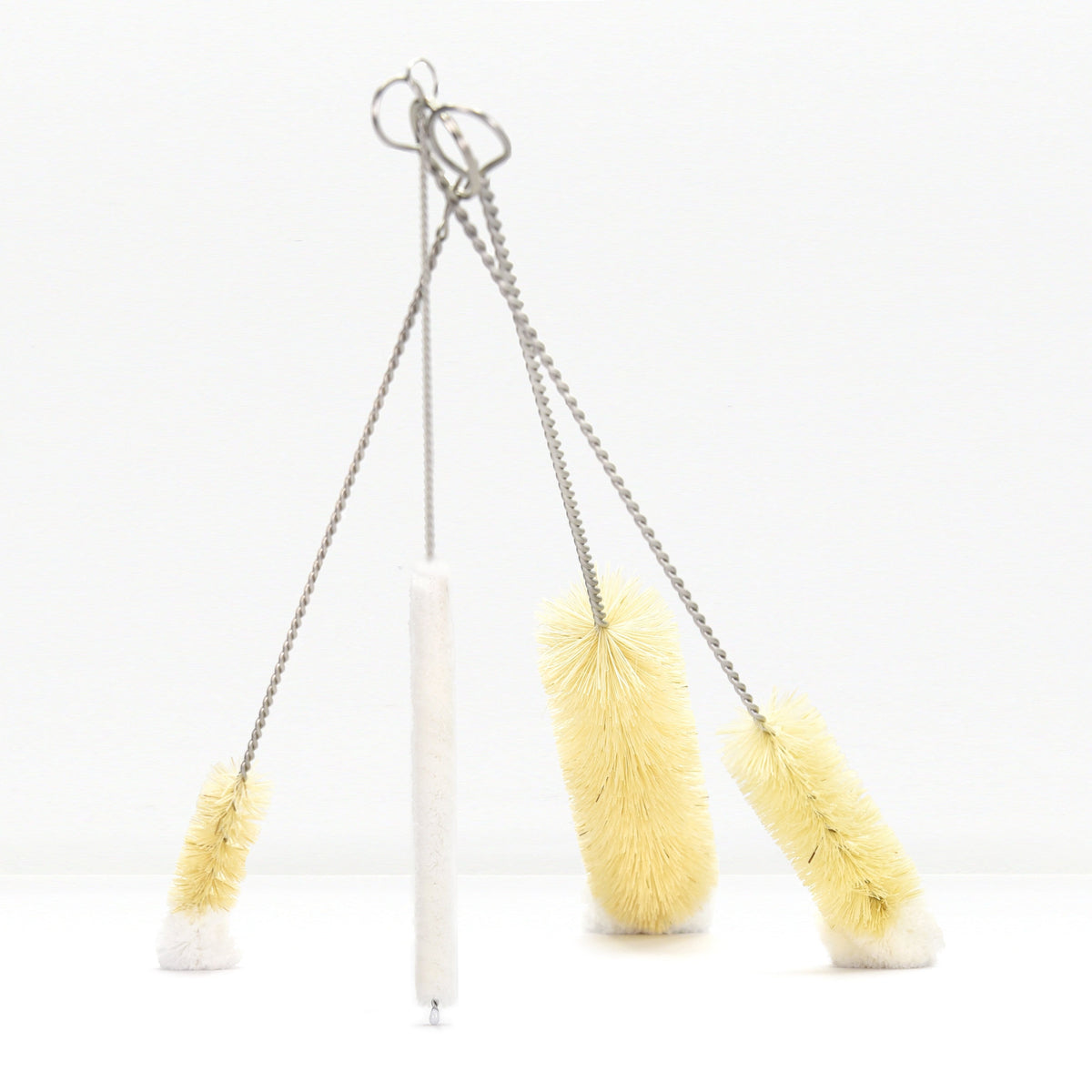 Set of five bottle brushes with twisted cords and metal hanging loops against a white background.