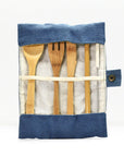 Fully opened bamboo cutlery set laid out in a blue denim roll against a white background.