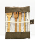 Bamboo cutlery set in a fabric roll with wooden spoons and utensils visible