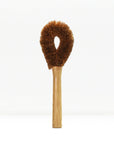Brown fluffy dish brush with wooden handle on a white background