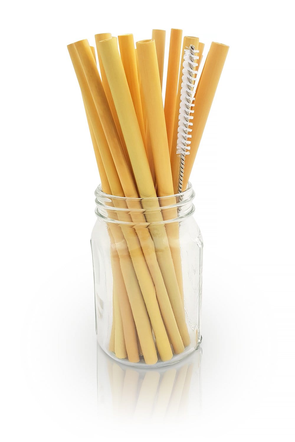 Glass jar filled with light brown bamboo drinking straws and a metal cleaning brush against a white background