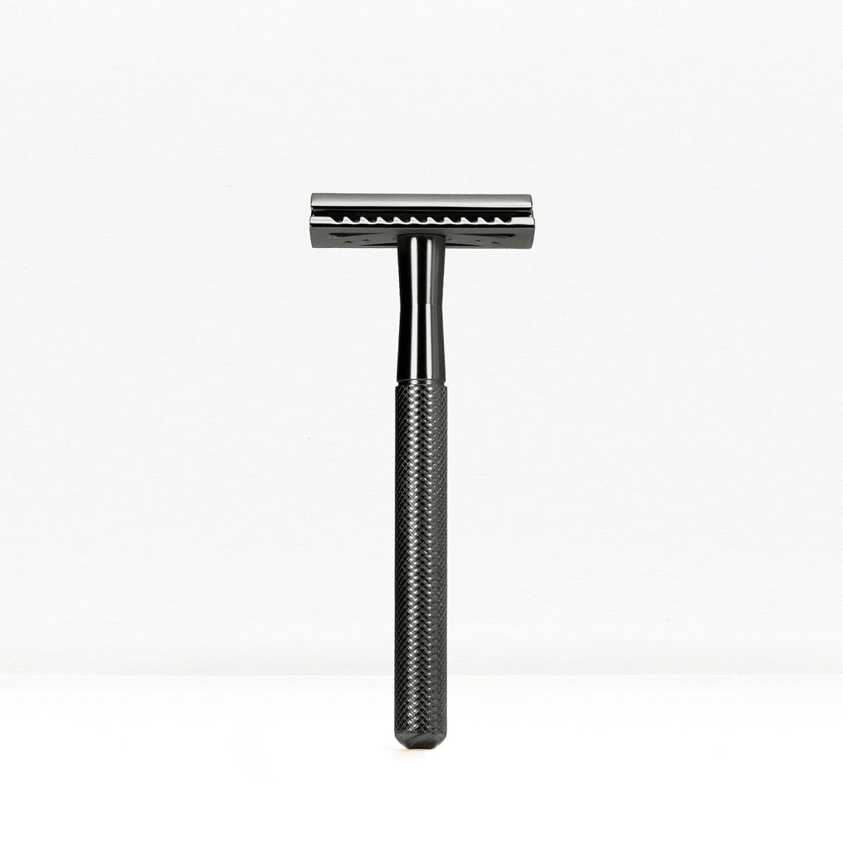 Black finish double edge safety razor with knurled handle standing upright.