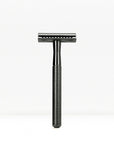Black finish double edge safety razor with knurled handle standing upright.