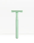 Mint green metal double edge safety razor with a knurled handle standing upright