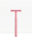 Pink metal double edge safety razor with textured handle against a white background