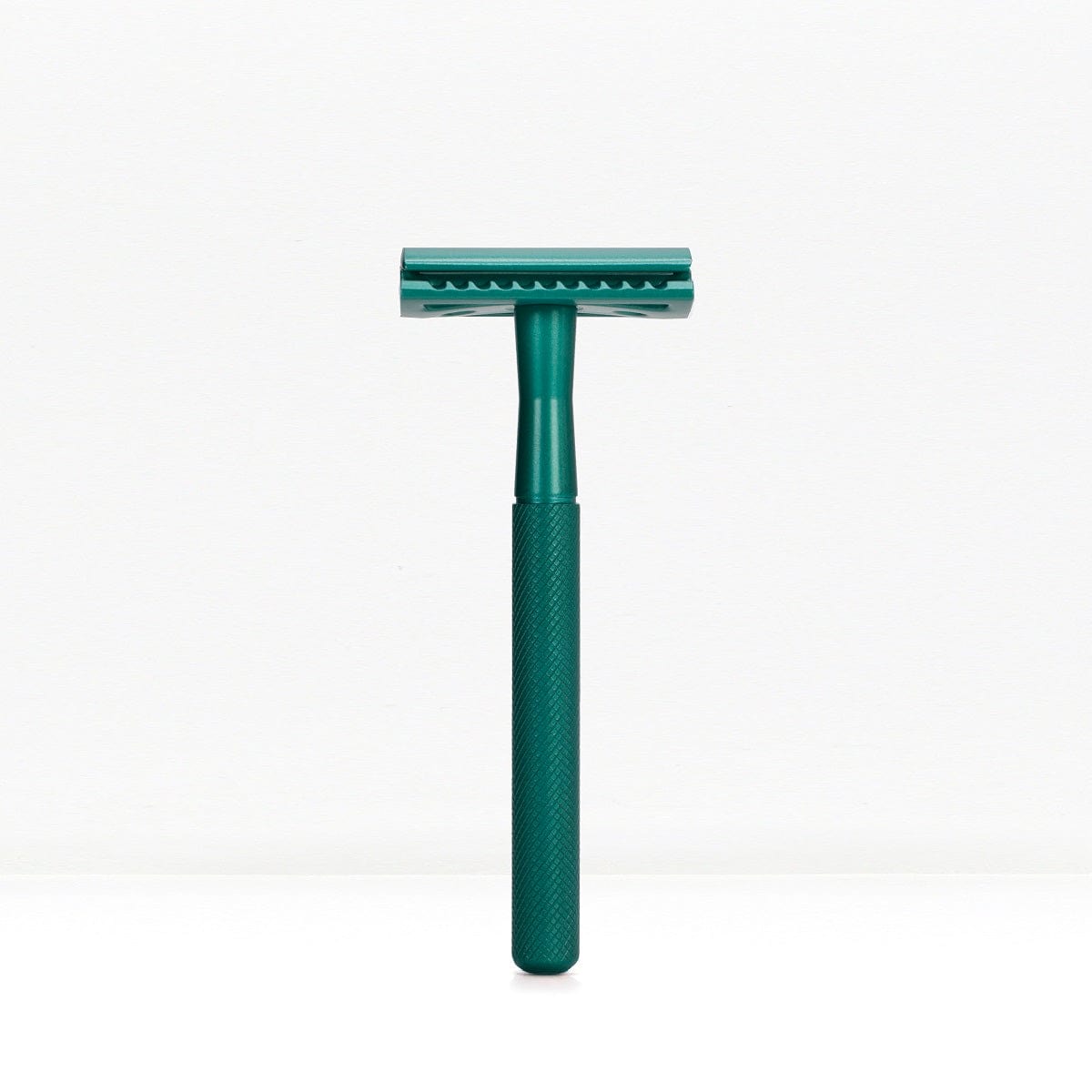 Teal metal double edge safety razor with a knurled handle standing upright