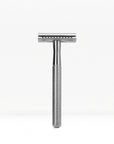 Chrome finished double edge safety razor with knurled handle standing upright.