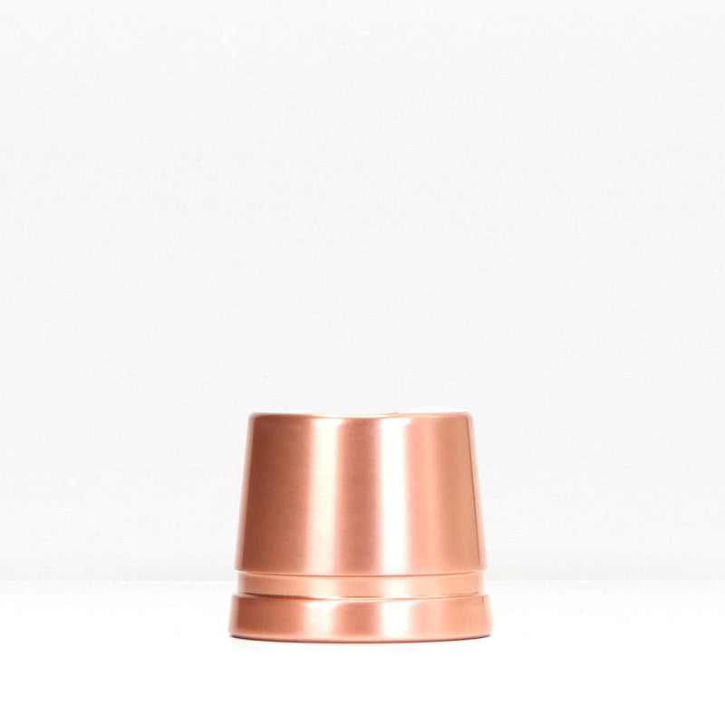 Copper safety razor stand on white surface with packaging box in background