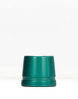 Teal metal safety razor stand on a white surface.
