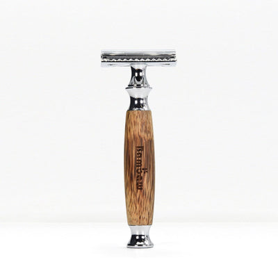 Bamboo safety razor with a natural wood grain handle and chrome head standing upright on a white background