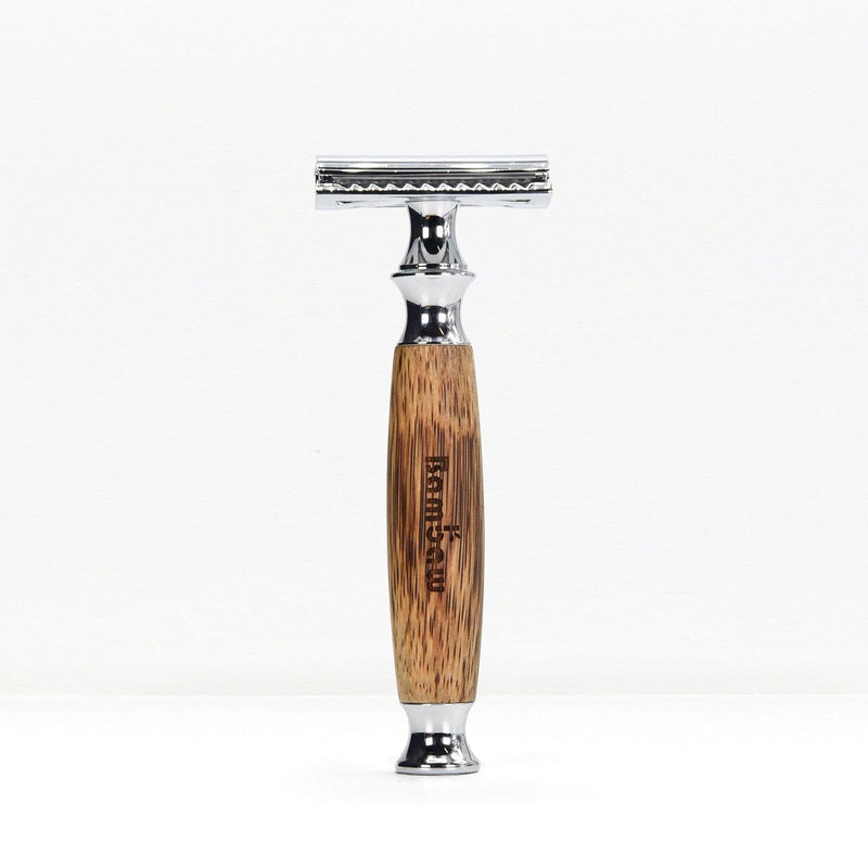 Bamboo safety razor with a natural wood grain handle and chrome head standing upright on a white background