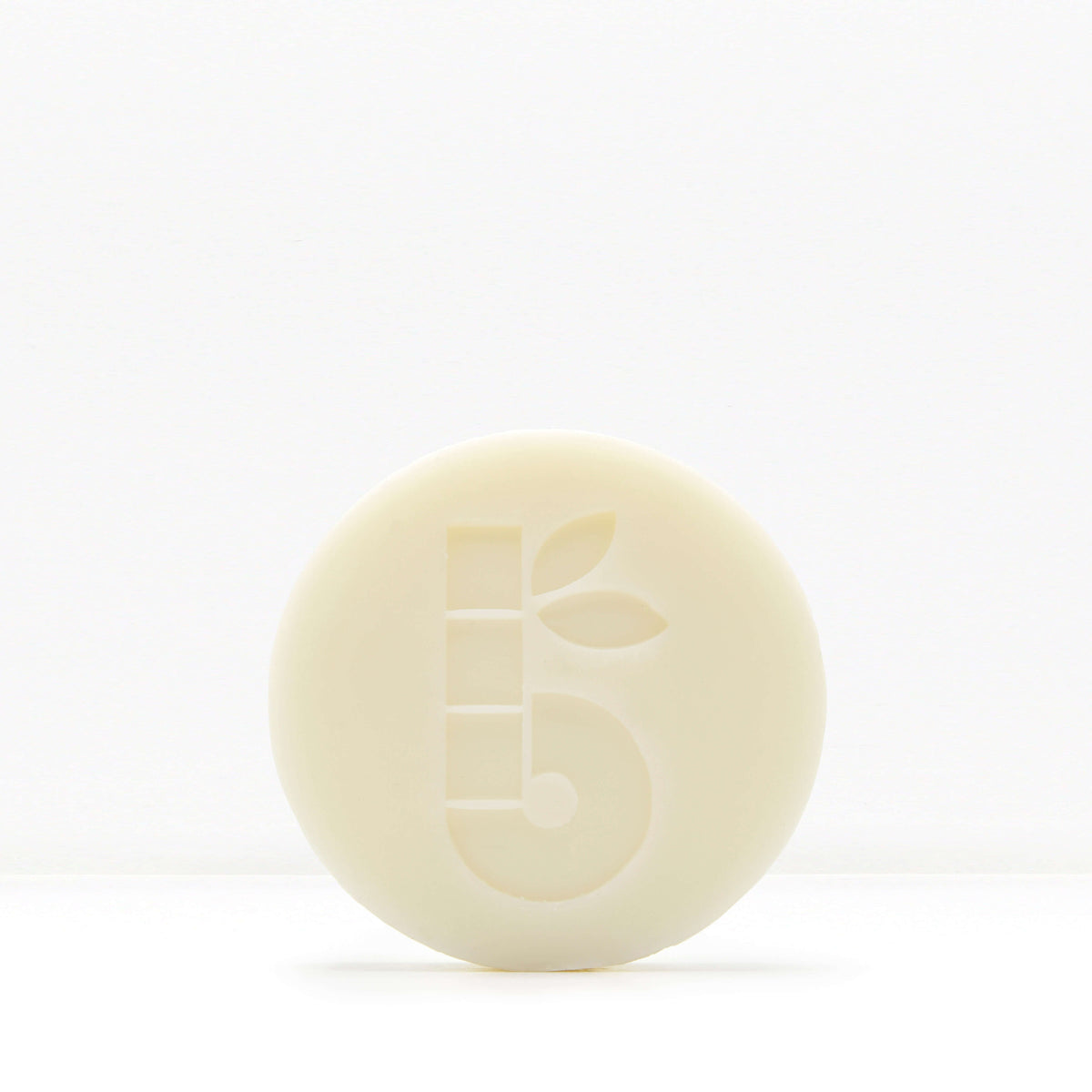 Partial view of a pale shaving bar with decorative geometric cutouts against a white background