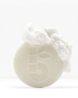 Shaving Bar product with foam on top of a white container against a clean white background