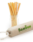 Bamboo drinking straws arranged in a glass jar with a cleaning brush and a beige cloth sleeve
